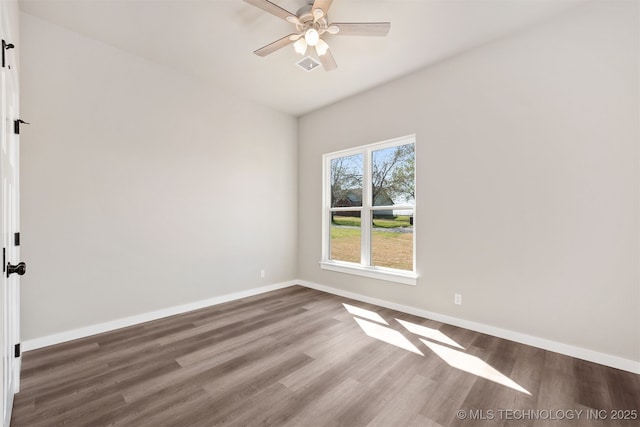 spare room with visible vents, ceiling fan, wood finished floors, and baseboards
