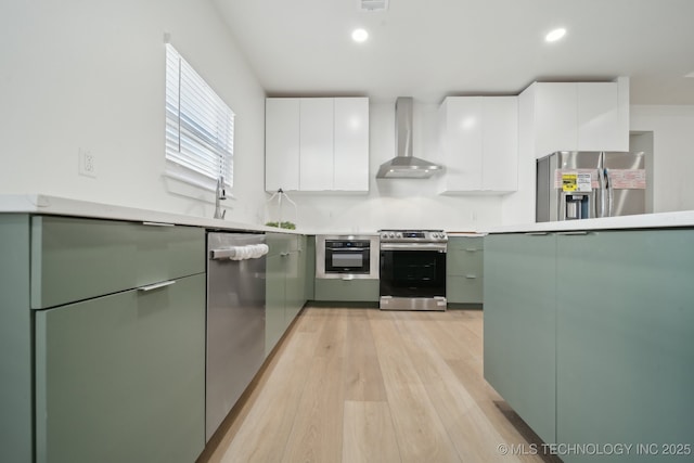 3306 Harbour Town Pl, Claremore, OK 74019 - kitchen featuring green cabinetry, stainless steel appliances, light wood-style flooring, modern cabinets, and wall chimney exhaust hood