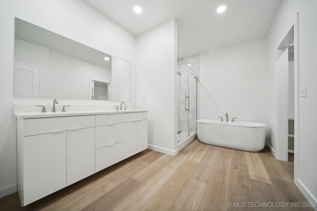 3306 Harbour Town Pl, Claremore, OK 74019 - full bathroom featuring a shower stall, a sink, a freestanding bath, double vanity, and wood finished floors