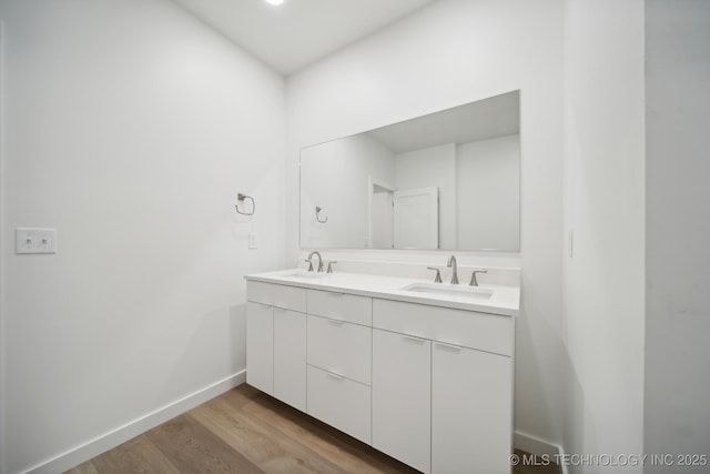 3306 Harbour Town Pl, Claremore, OK 74019 - bathroom featuring baseboards, wood finished floors, double vanity, and a sink