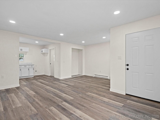 unfurnished living room featuring baseboards, wood finished floors, recessed lighting, and baseboard heating