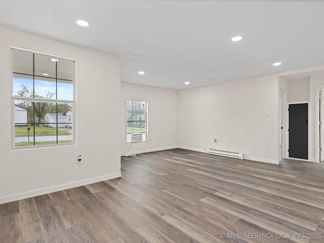 empty room featuring a baseboard radiator, wood finished floors, baseboards, and recessed lighting