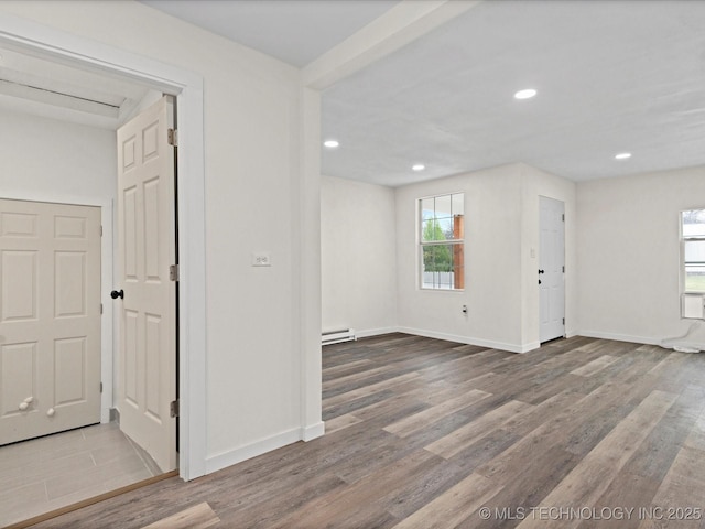 unfurnished room with recessed lighting, baseboards, a baseboard heating unit, and wood finished floors