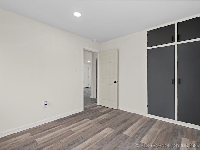 unfurnished bedroom featuring recessed lighting, baseboards, and wood finished floors