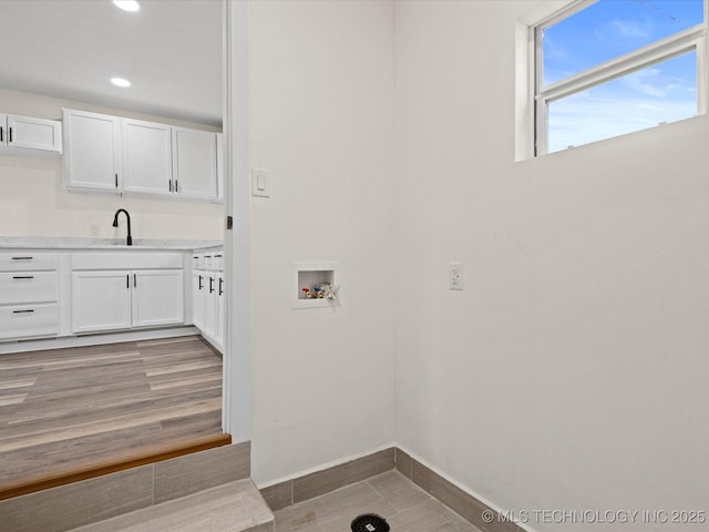 clothes washing area with light wood-style flooring, washer hookup, laundry area, recessed lighting, and a sink