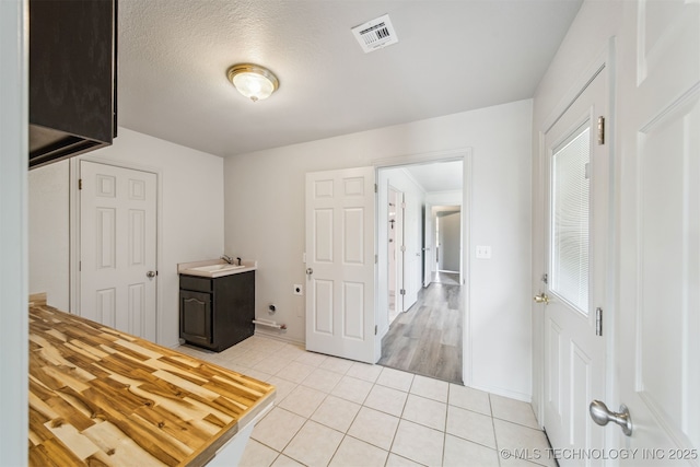 9839 N Lewis Ave, Sperry, OK 74073 - interior space featuring laundry area, a sink, light tile patterned floors, hookup for an electric dryer, and visible vents