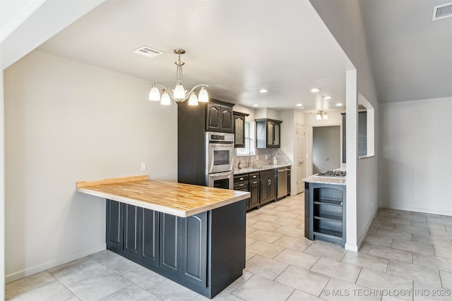 9839 N Lewis Ave, Sperry, OK 74073 - kitchen featuring a sink, stainless steel appliances, a peninsula, backsplash, and visible vents