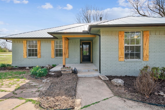 9839 N Lewis Ave, Sperry, OK 74073 - doorway to property featuring brick siding and metal roof