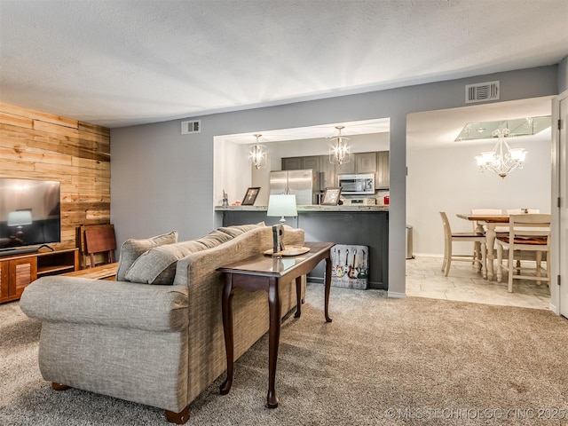 6510 S Memorial Dr Unit G, Tulsa, OK 74133 - living room featuring light carpet, a notable chandelier, visible vents, and wood walls