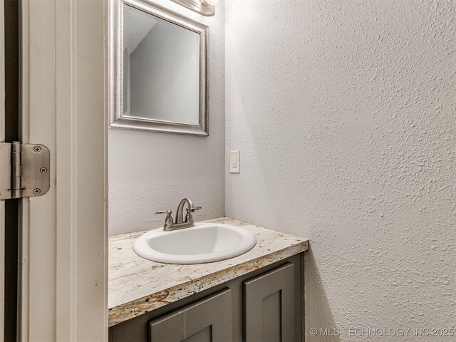 6510 S Memorial Dr Unit G, Tulsa, OK 74133 - bathroom featuring vanity and a textured wall