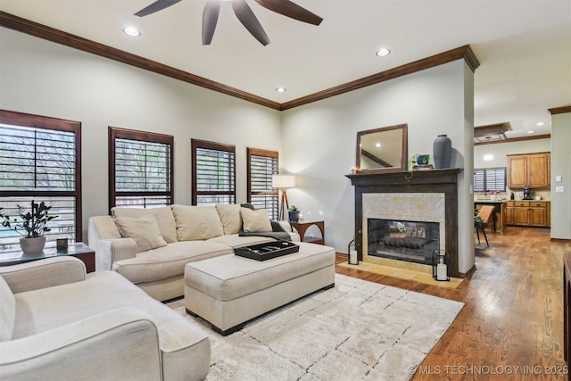 626 Countrywood Way, Sapulpa, OK 74066 - living room with crown molding, ceiling fan, a fireplace, light wood-style flooring, and recessed lighting