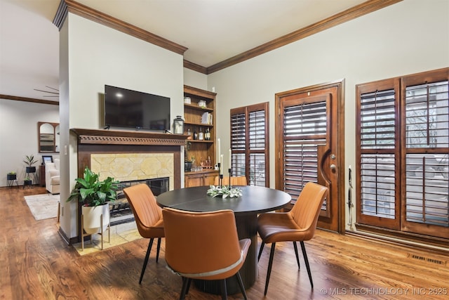 626 Countrywood Way, Sapulpa, OK 74066 - dining space featuring ornamental molding, a fireplace, and wood finished floors