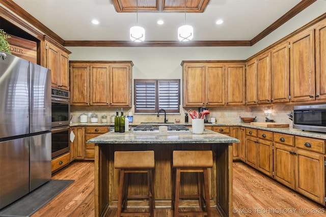 626 Countrywood Way, Sapulpa, OK 74066 - kitchen with stainless steel appliances, crown molding, brown cabinetry, light wood finished floors, and a kitchen breakfast bar