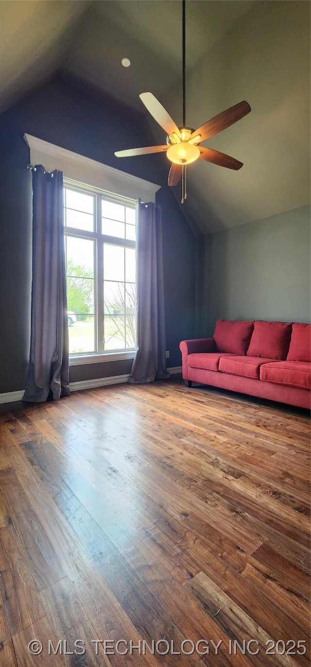 living area with ceiling fan, lofted ceiling, and wood finished floors