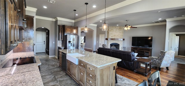 kitchen featuring a ceiling fan, a sink, dishwasher, arched walkways, and stainless steel refrigerator with ice dispenser