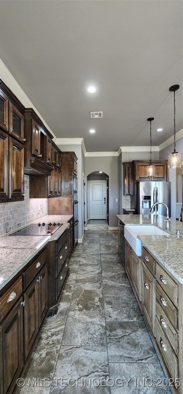 kitchen with ornamental molding, arched walkways, backsplash, and black appliances