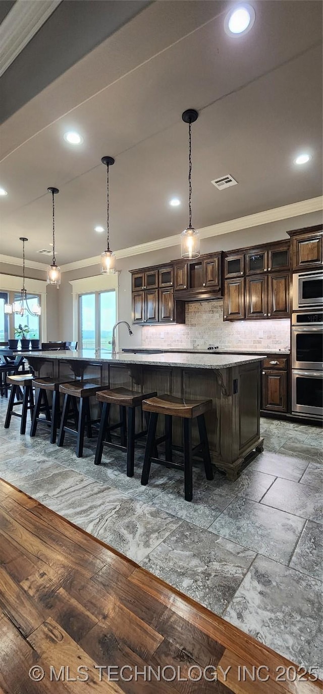 bar with decorative light fixtures, appliances with stainless steel finishes, tasteful backsplash, and recessed lighting