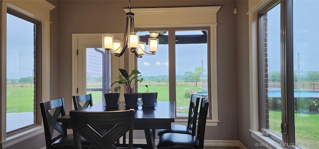 dining room featuring baseboards, an inviting chandelier, and plenty of natural light