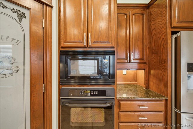 6673 E 60th Pl, Tulsa, OK 74145 - kitchen with wall oven, stainless steel fridge, black microwave, dark stone countertops, and tile patterned flooring