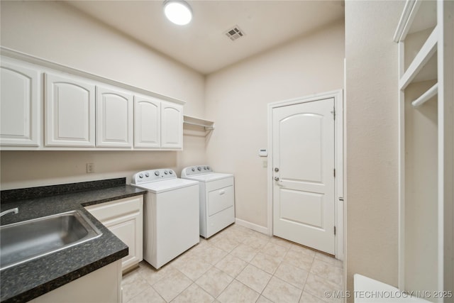 6673 E 60th Pl, Tulsa, OK 74145 - laundry area featuring washing machine and dryer, light tile patterned floors, and cabinet space
