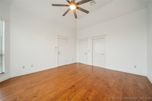 6673 E 60th Pl, Tulsa, OK 74145 - empty room featuring a ceiling fan, wood finished floors, baseboards, and a high ceiling