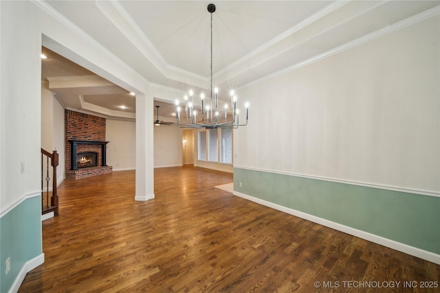 6673 E 60th Pl, Tulsa, OK 74145 - unfurnished dining area featuring wood finished floors, a fireplace, a chandelier, crown molding, and a raised ceiling