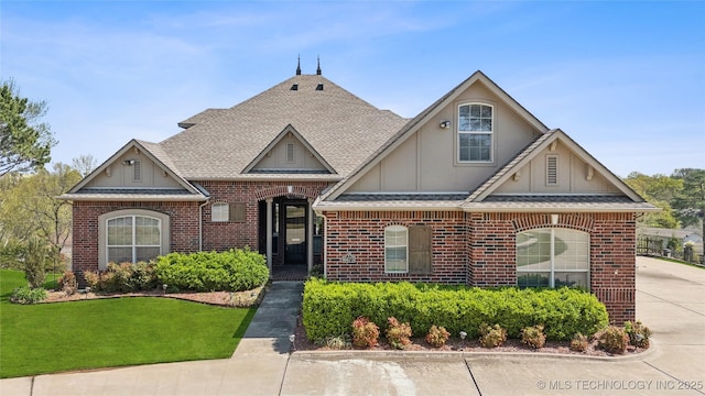 6673 E 60th Pl, Tulsa, OK 74145 - view of front of property featuring brick siding, roof with shingles, a front yard, and board and batten siding