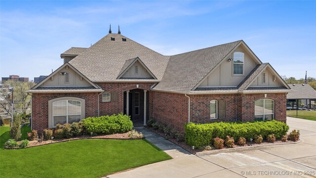 6673 E 60th Pl, Tulsa, OK 74145 - english style home featuring brick siding, roof with shingles, and a front lawn