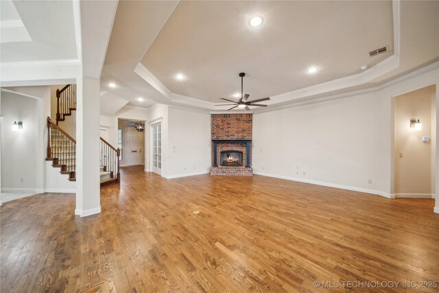 6673 E 60th Pl, Tulsa, OK 74145 - unfurnished living room with ceiling fan, a tray ceiling, a fireplace, ornamental molding, and stairs