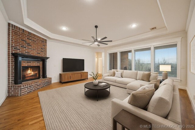 6673 E 60th Pl, Tulsa, OK 74145 - living area featuring a raised ceiling, a ceiling fan, wood finished floors, ornamental molding, and baseboards