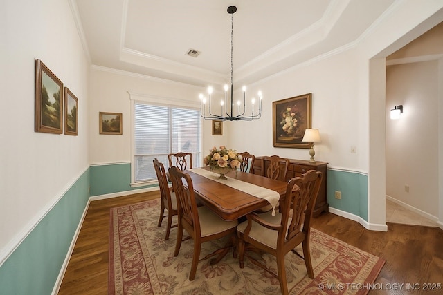 6673 E 60th Pl, Tulsa, OK 74145 - dining room featuring a tray ceiling, a chandelier, wood finished floors, ornamental molding, and baseboards