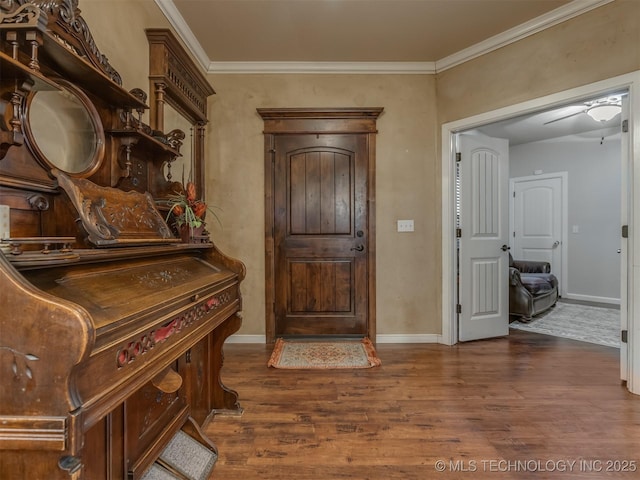 entrance foyer with crown molding, baseboards, and dark wood-style flooring