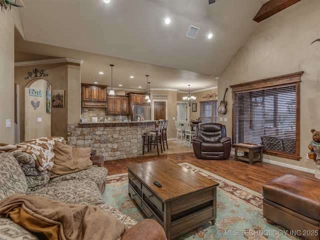 living room featuring vaulted ceiling, light wood-style floors, an inviting chandelier, visible vents, and recessed lighting