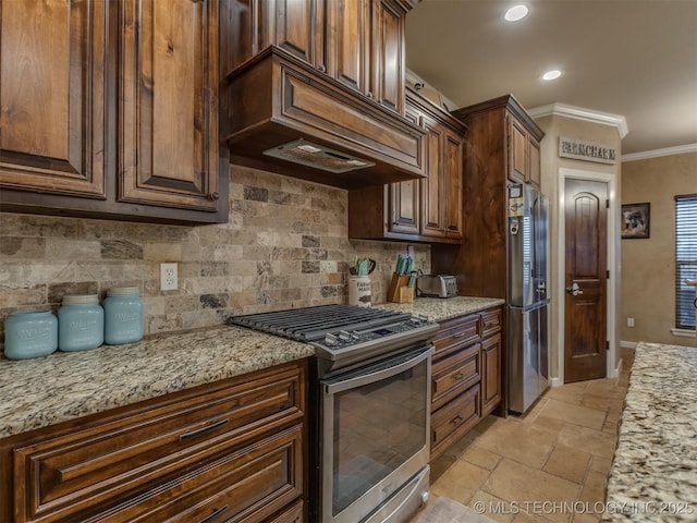 kitchen featuring stone tile floors, baseboards, decorative backsplash, crown molding, and appliances with stainless steel finishes
