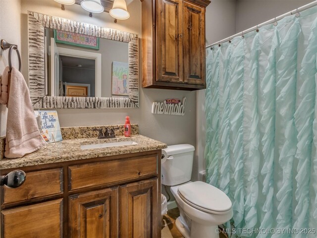 bathroom featuring vanity, curtained shower, and toilet