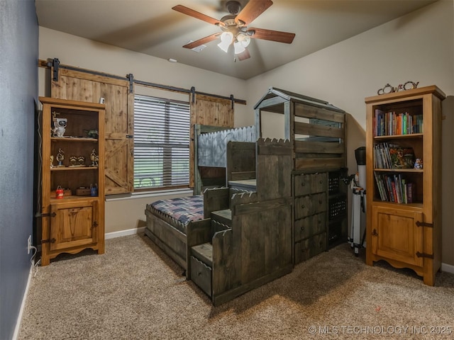 bedroom with a barn door, carpet floors, and baseboards
