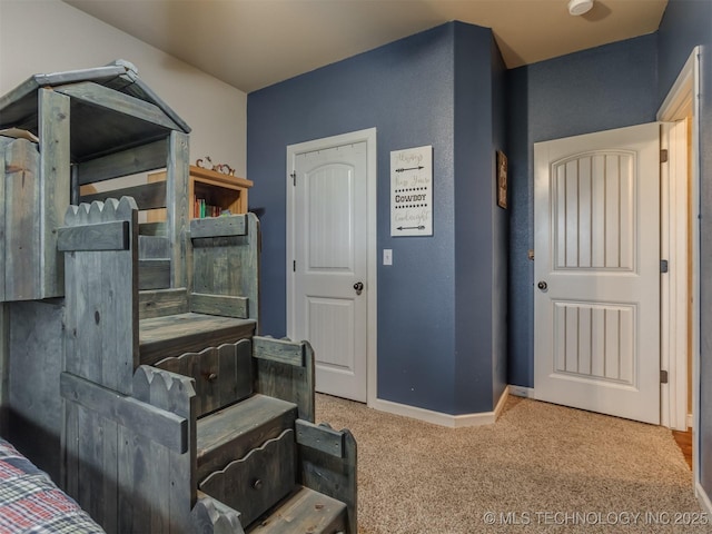 bedroom featuring baseboards and carpet