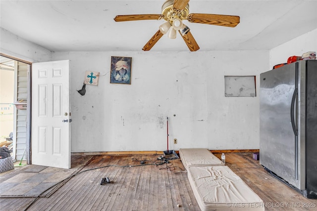 interior space with wood-type flooring, freestanding refrigerator, and a ceiling fan