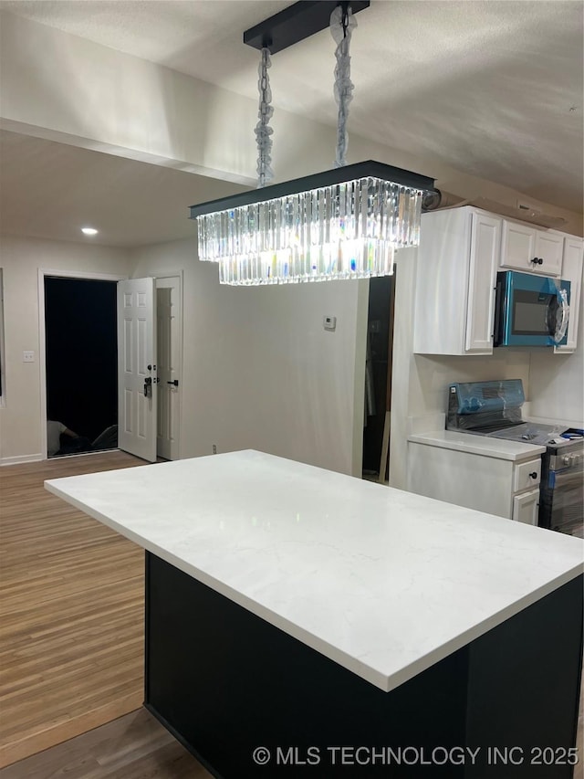 4232 N Hartford Ave, Tulsa, OK 74106 - kitchen featuring wood finished floors, light countertops, white cabinetry, and range with electric stovetop