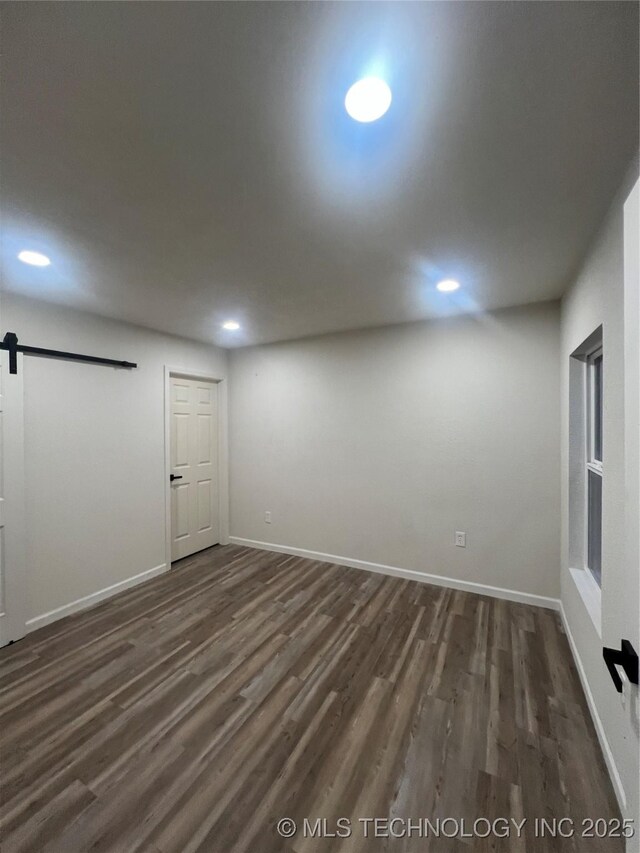 4232 N Hartford Ave, Tulsa, OK 74106 - below grade area featuring recessed lighting, dark wood-type flooring, a barn door, and baseboards