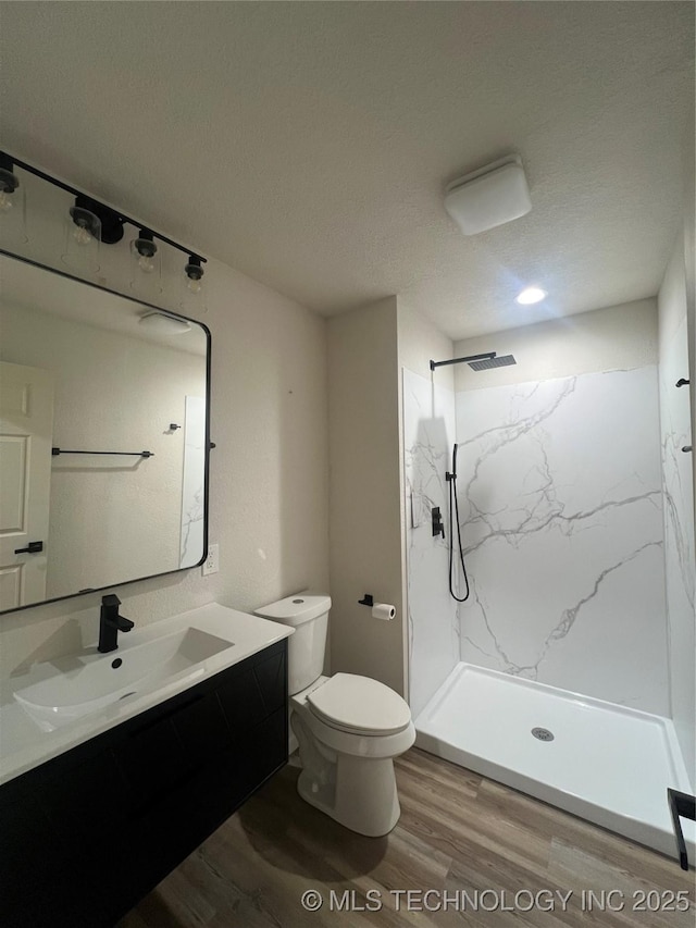 4232 N Hartford Ave, Tulsa, OK 74106 - bathroom featuring vanity, visible vents, toilet, wood finished floors, and a marble finish shower