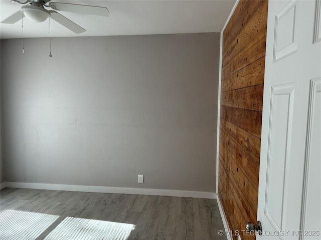 218 SW B, Ardmore, OK 73401 - spare room with a ceiling fan, wood finished floors, baseboards, and wooden walls