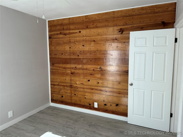 218 SW B, Ardmore, OK 73401 - unfurnished room with baseboards, wood finished floors, and wooden walls