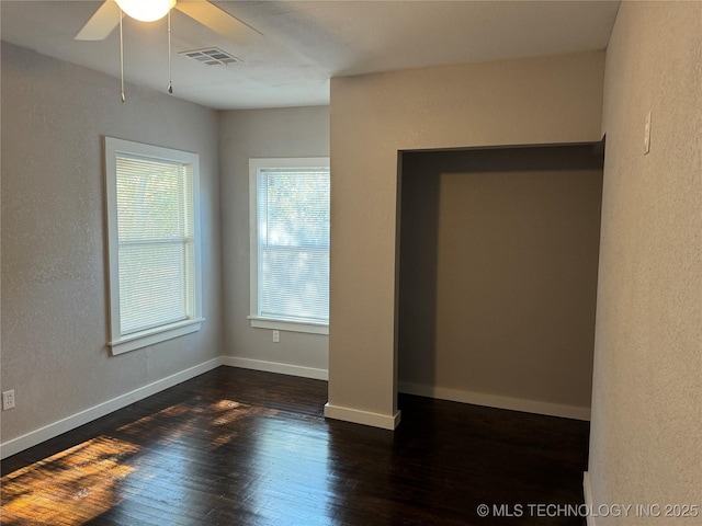 218 SW B, Ardmore, OK 73401 - unfurnished bedroom with dark wood-style flooring, ceiling fan, baseboards, and a textured wall
