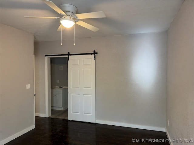 218 SW B, Ardmore, OK 73401 - unfurnished room featuring ceiling fan, baseboards, a barn door, wood finished floors, and a sink