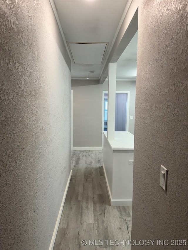 218 SW B, Ardmore, OK 73401 - hall featuring a textured wall, attic access, wood finished floors, and baseboards