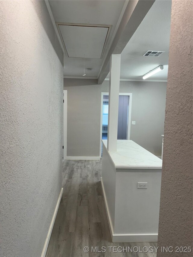 218 SW B, Ardmore, OK 73401 - hallway featuring attic access, a textured wall, wood finished floors, and baseboards
