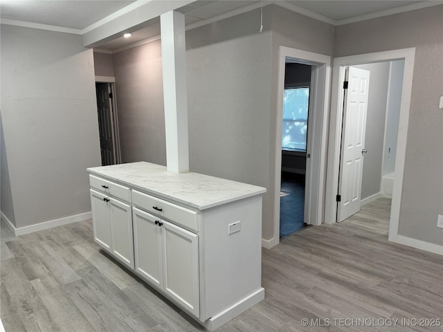 218 SW B, Ardmore, OK 73401 - kitchen featuring ornamental molding, light wood-style flooring, white cabinetry, baseboards, and a center island