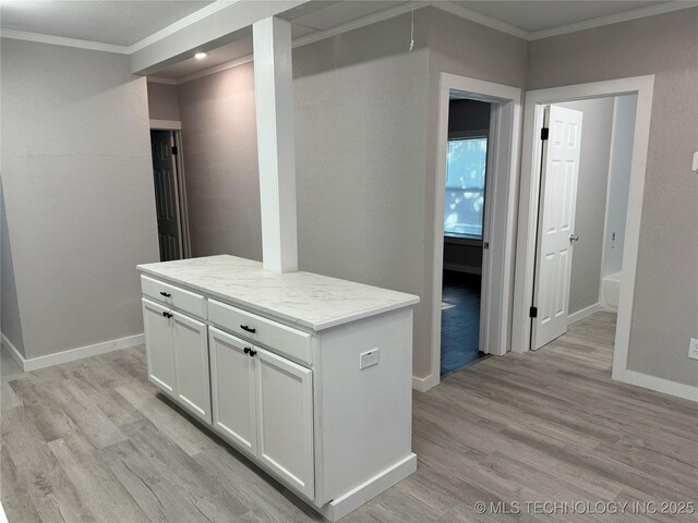 218 SW B, Ardmore, OK 73401 - kitchen featuring ornamental molding, light wood-style flooring, white cabinetry, baseboards, and a center island