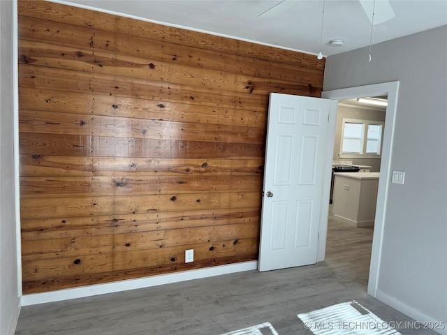 218 SW B, Ardmore, OK 73401 - empty room with wood finished floors, wooden walls, baseboards, and a smoke detector